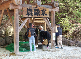 人々が湧き出ている炭酸水を飲んでいる